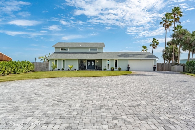 view of front of property with a front yard and a garage