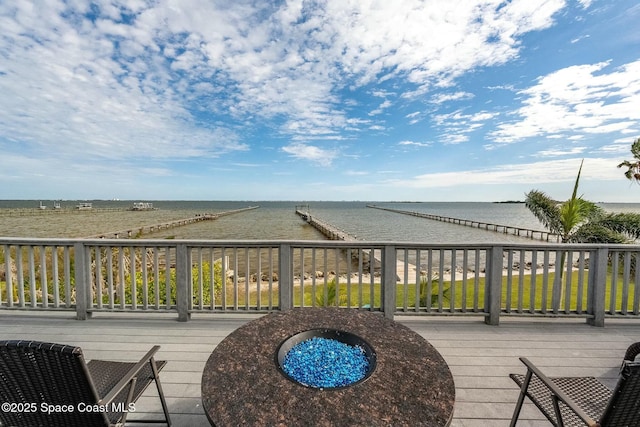 deck with a fire pit and a water view