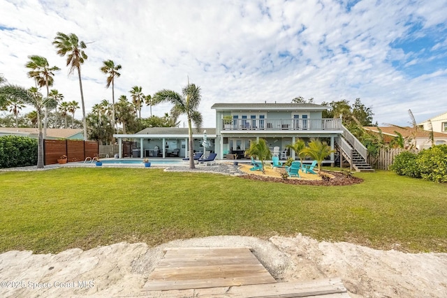 back of property with a balcony, a fenced in pool, a yard, and a patio