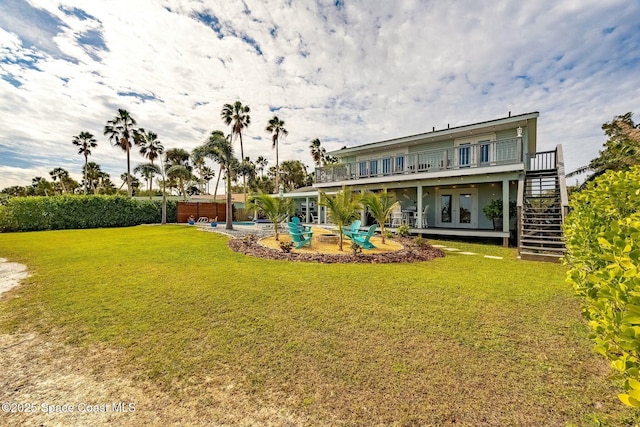 back of house featuring a lawn, french doors, a patio area, and a pool