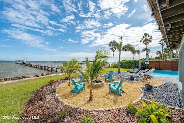 exterior space with a water view, a patio area, a dock, and a fire pit