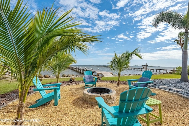 view of property's community featuring an outdoor fire pit and a water view