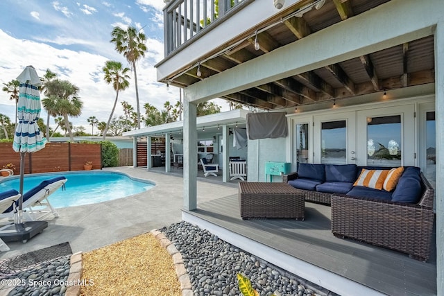 view of pool with french doors, a deck, a patio area, and outdoor lounge area