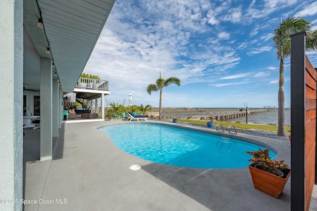 view of pool featuring a patio area and a water view