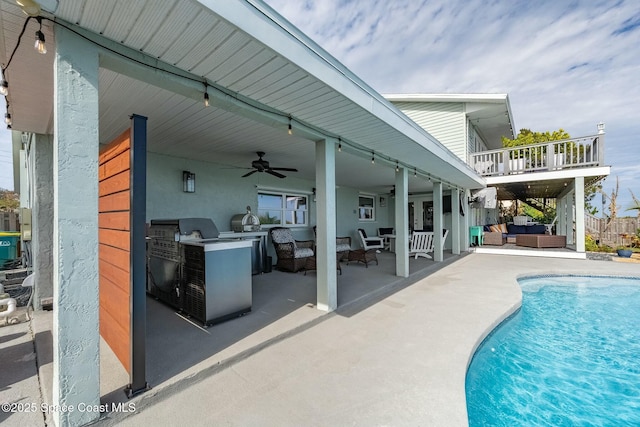 view of pool featuring ceiling fan, a patio area, an outdoor kitchen, and outdoor lounge area