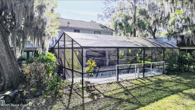 exterior space featuring a lanai and a lawn