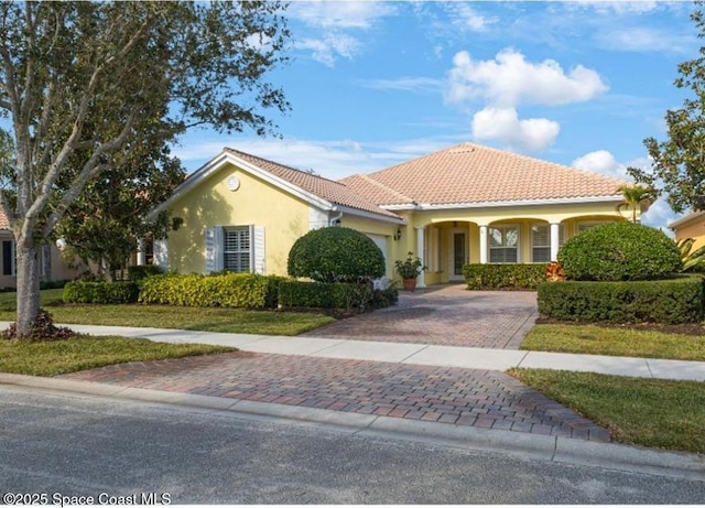 mediterranean / spanish-style house with covered porch and a front lawn