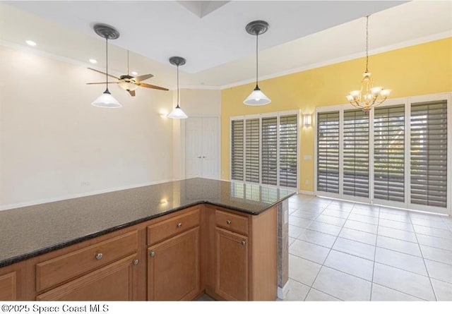 kitchen with pendant lighting, ceiling fan with notable chandelier, light tile patterned floors, and crown molding