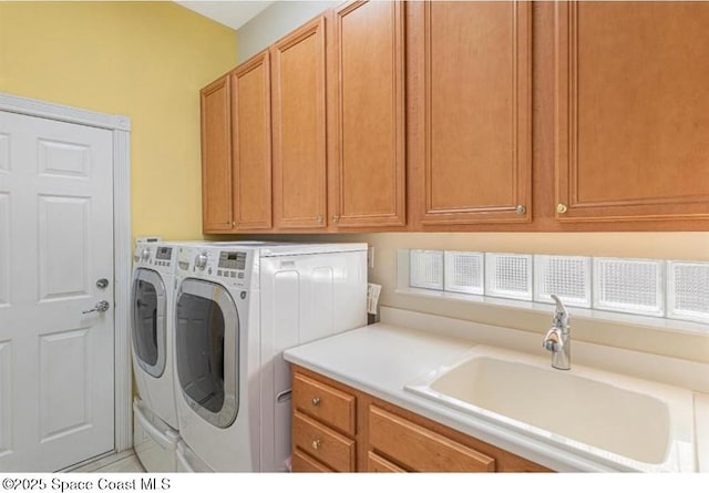 washroom featuring washer and clothes dryer, sink, and cabinets