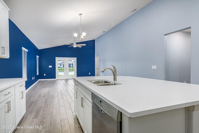 kitchen featuring dishwashing machine, sink, white cabinetry, and an island with sink