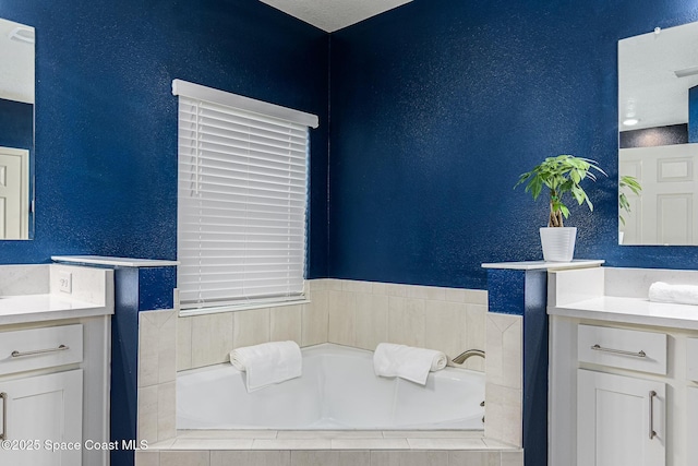 bathroom with vanity and tiled bath