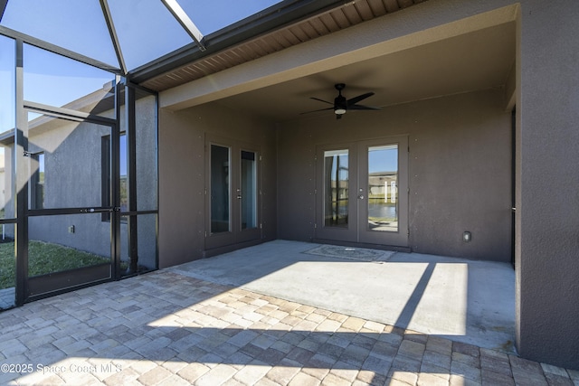 view of patio with french doors, ceiling fan, and glass enclosure