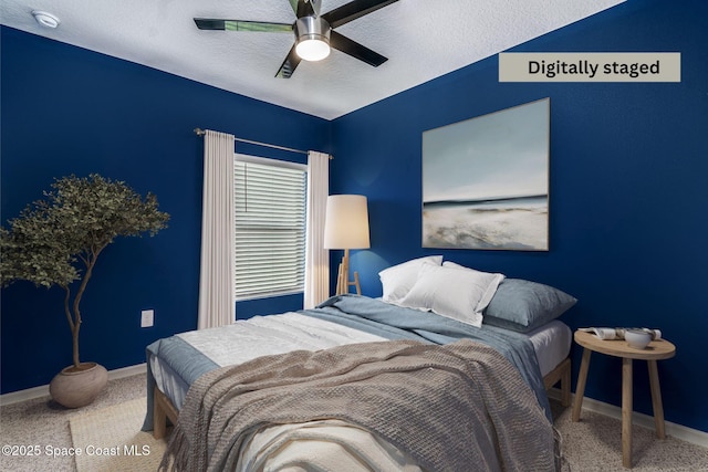 bedroom with ceiling fan and a textured ceiling