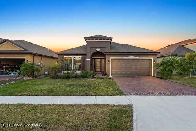 prairie-style house with a garage and a yard