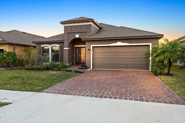 prairie-style home with a garage and a yard