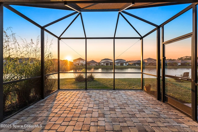 unfurnished sunroom featuring a water view