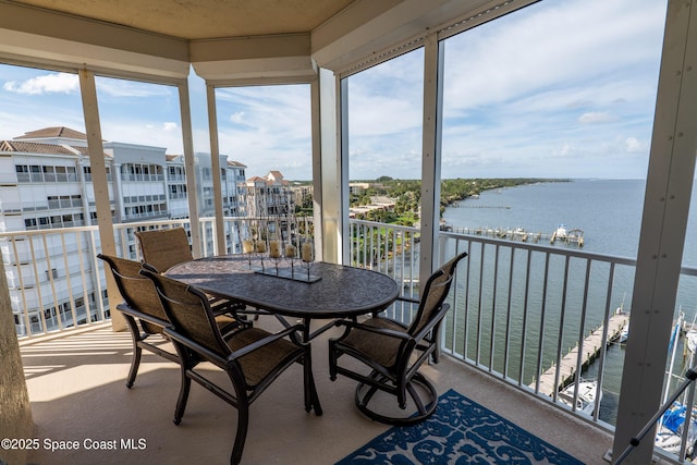 sunroom / solarium featuring a water view