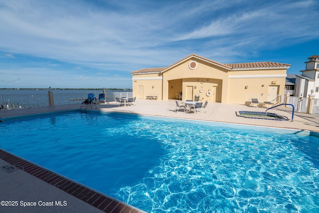 view of pool with a patio and a water view