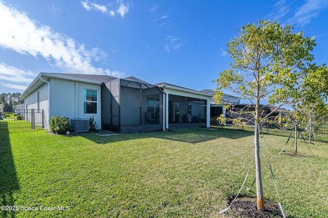 back of property with a lawn, central air condition unit, a sunroom, and a lanai