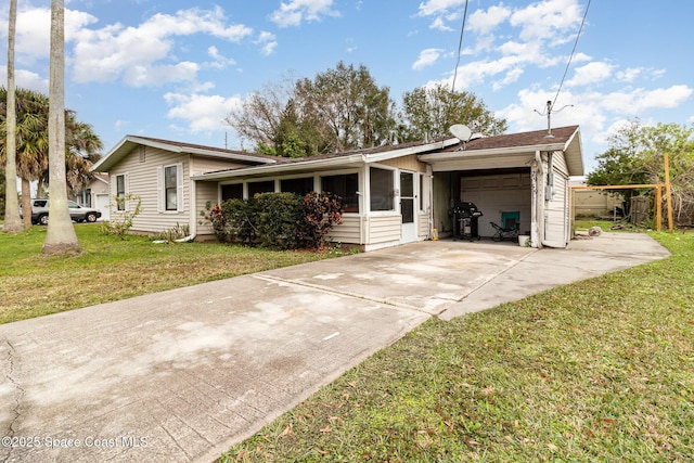 ranch-style house with a sunroom, a front lawn, and a garage