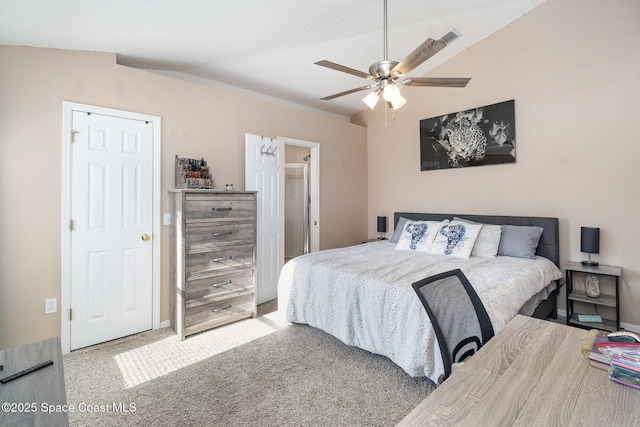 bedroom featuring light carpet, a textured ceiling, ceiling fan, and lofted ceiling