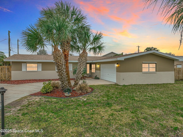 ranch-style home with a garage and a lawn