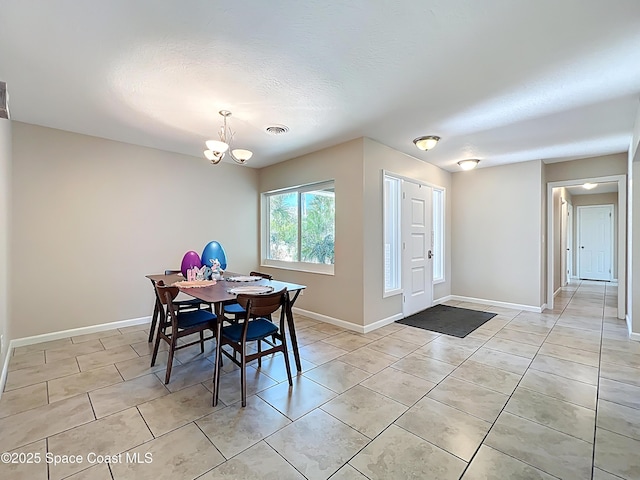 dining room with a textured ceiling, a chandelier, light tile patterned floors, baseboards, and visible vents