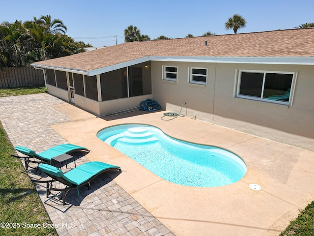 view of swimming pool with a fenced in pool, a sunroom, a patio, and fence