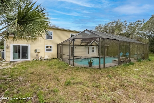 rear view of property featuring a lanai and a yard