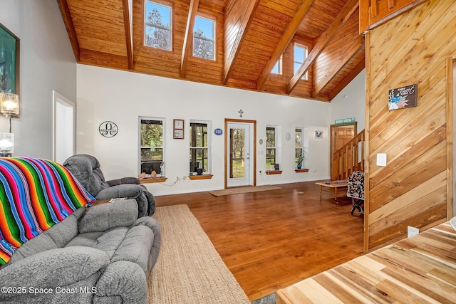 living room with a towering ceiling, beam ceiling, wood ceiling, and wood-type flooring