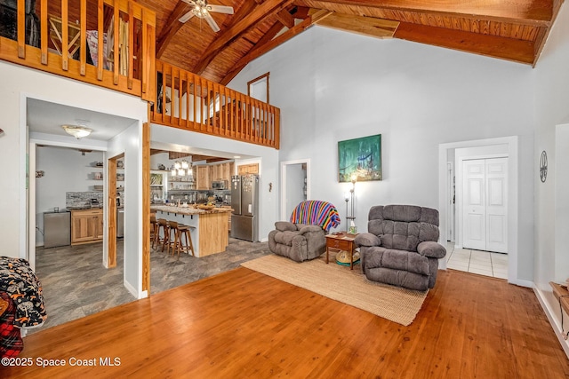 living room with high vaulted ceiling, light hardwood / wood-style flooring, and wooden ceiling