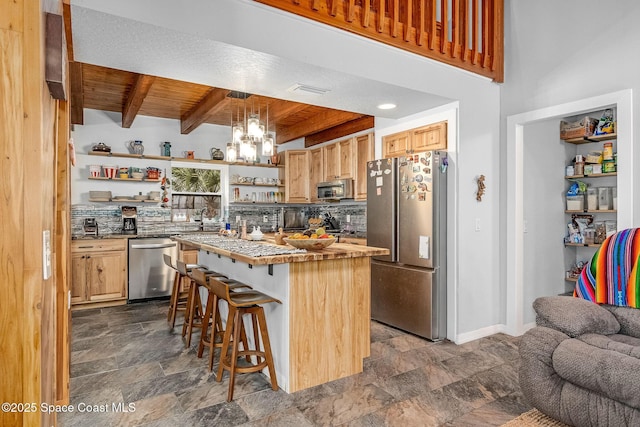 kitchen with a kitchen breakfast bar, wooden ceiling, appliances with stainless steel finishes, beamed ceiling, and a kitchen island