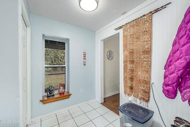 interior space with a textured ceiling and light tile patterned flooring