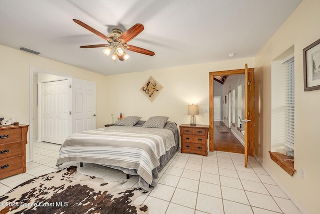 tiled bedroom featuring ceiling fan and a closet