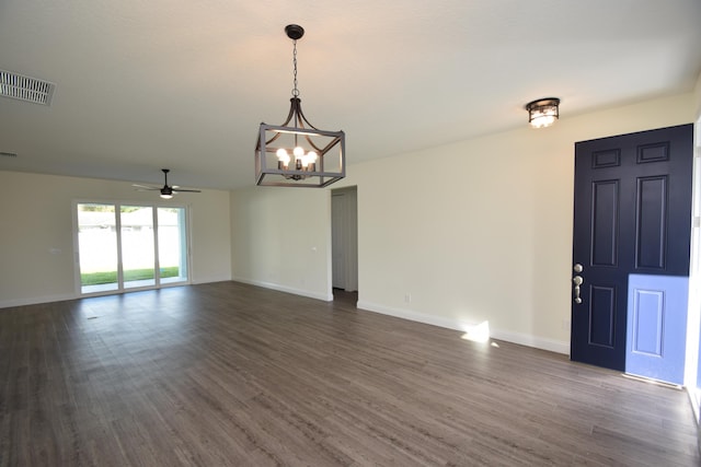 spare room with ceiling fan with notable chandelier and dark hardwood / wood-style flooring