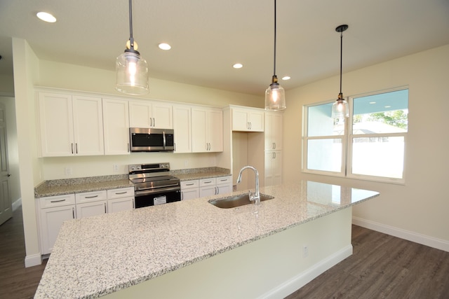 kitchen with sink, white cabinets, decorative light fixtures, and appliances with stainless steel finishes