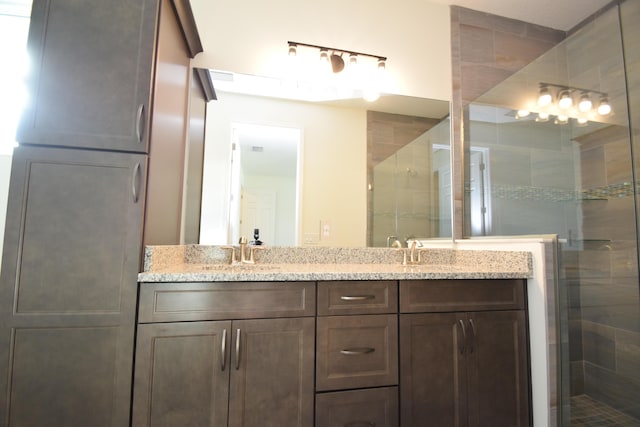 bathroom with a shower with door and vanity