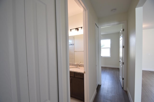 hallway featuring hardwood / wood-style floors and sink