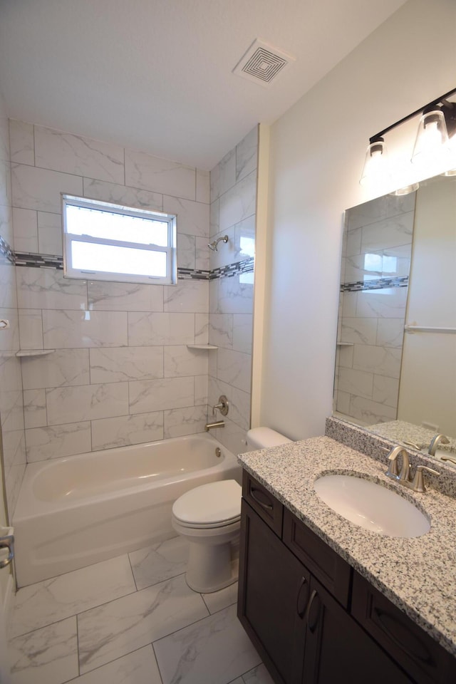 full bathroom with toilet, vanity, and tiled shower / bath