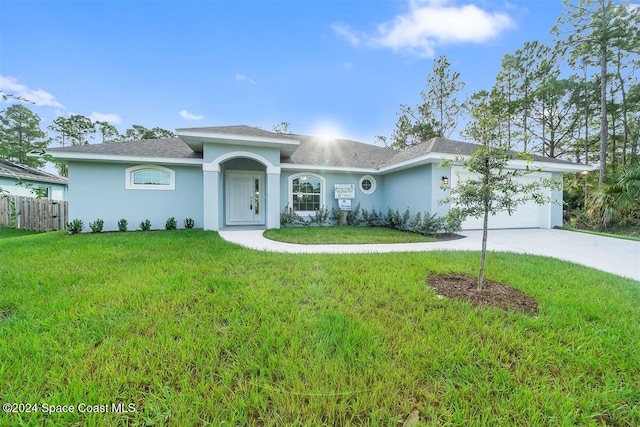 ranch-style home with a garage and a front lawn