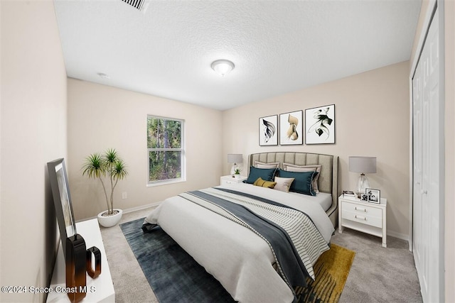 carpeted bedroom with a textured ceiling and a closet