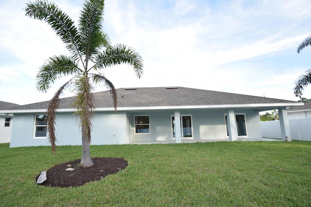 rear view of house featuring a yard