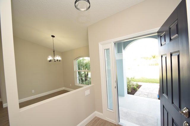 foyer entrance with hardwood / wood-style floors and a chandelier