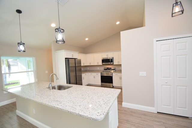 kitchen featuring stainless steel appliances, white cabinetry, hanging light fixtures, and sink