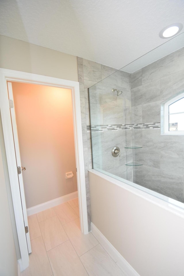 bathroom featuring tile patterned floors and tiled shower