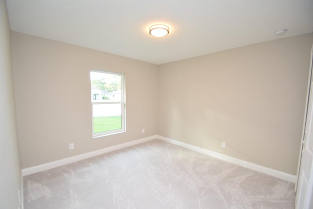 spare room featuring light colored carpet