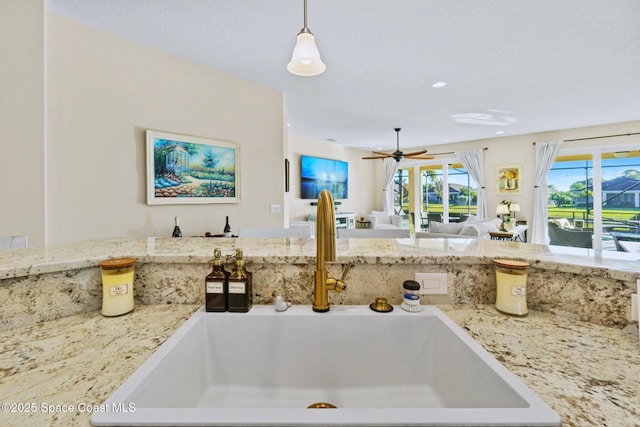 kitchen featuring ceiling fan, sink, and hanging light fixtures