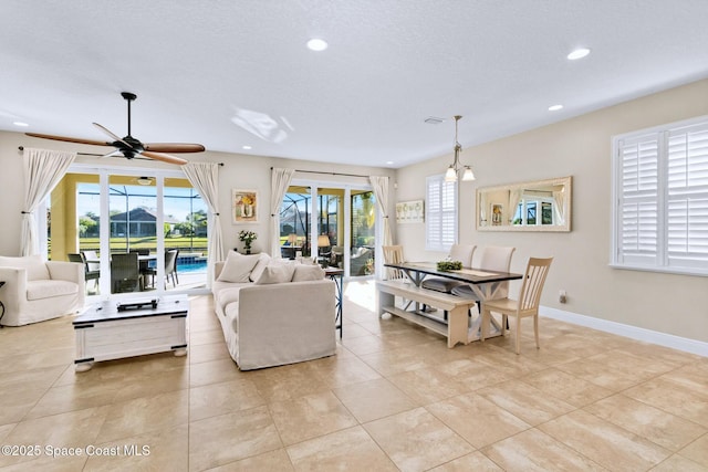 tiled living room with ceiling fan and a textured ceiling