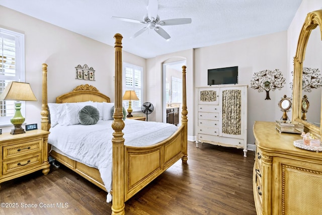 bedroom featuring ceiling fan, dark hardwood / wood-style floors, a textured ceiling, and connected bathroom