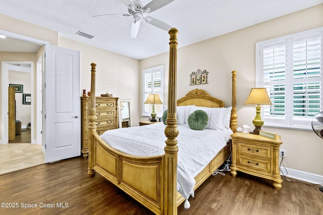 bedroom featuring a textured ceiling, ceiling fan, and dark wood-type flooring